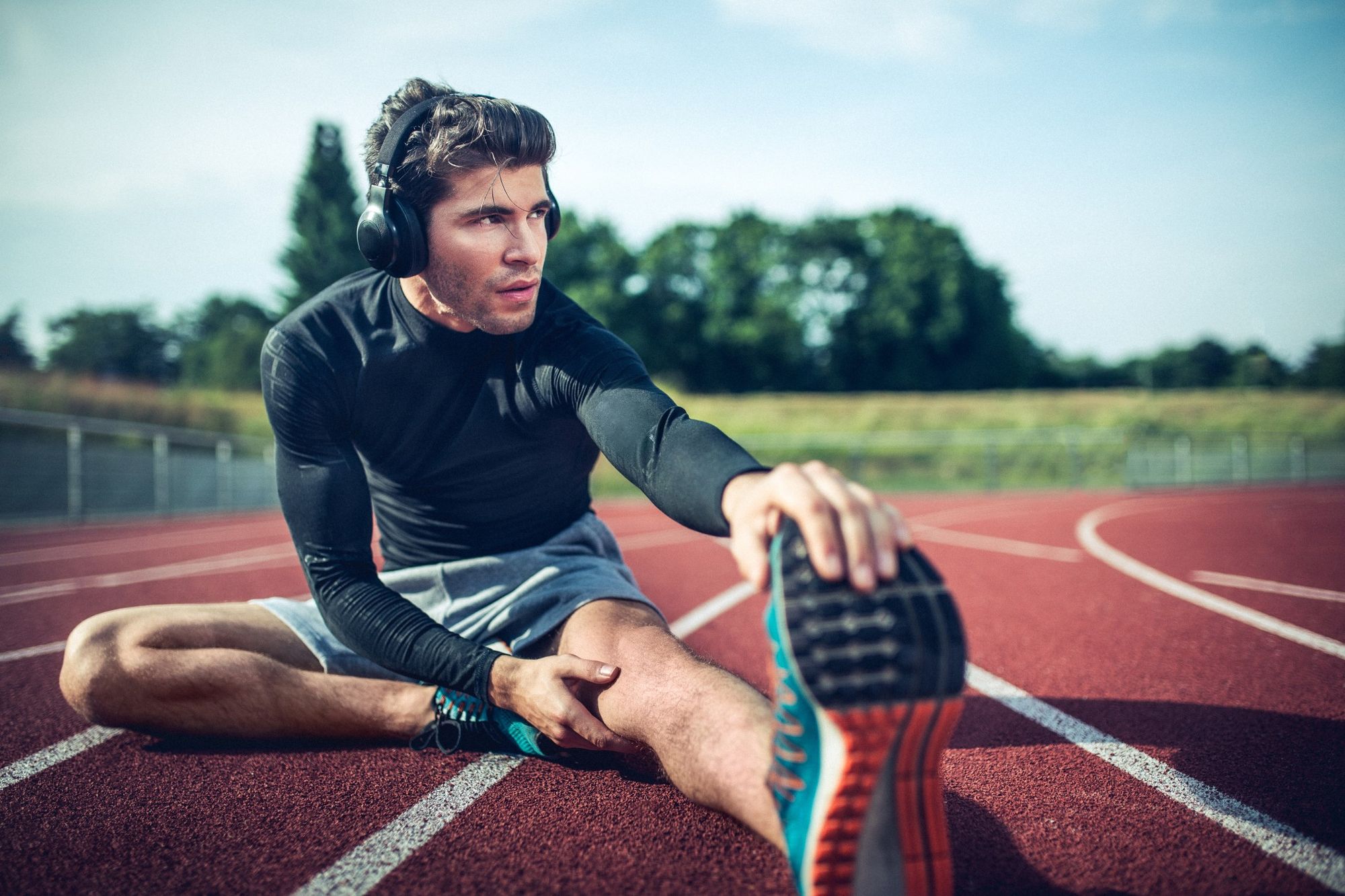 Man is doing stretching for his workout on running track