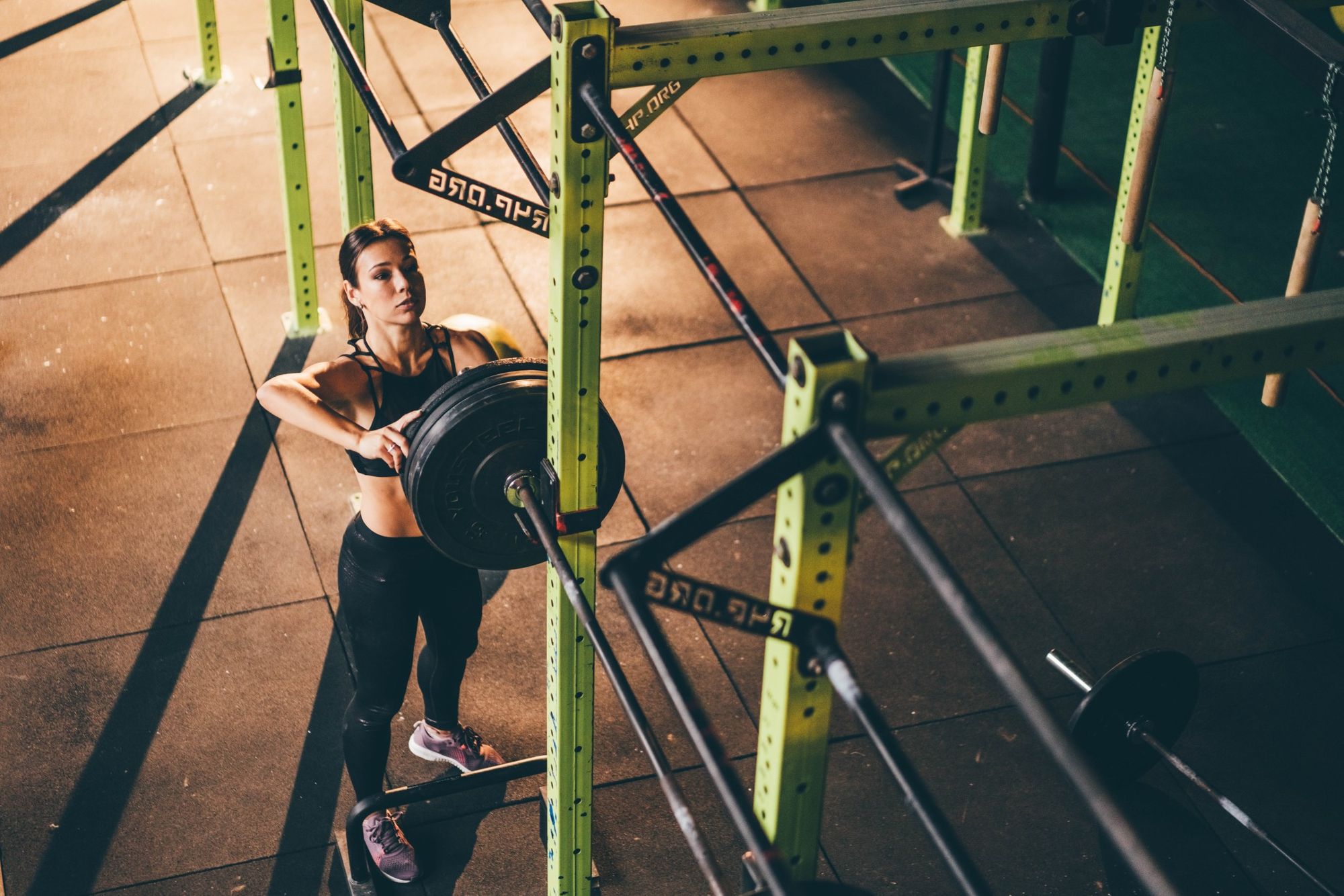 beautiful sportive woman with barbell on shoulders in gym