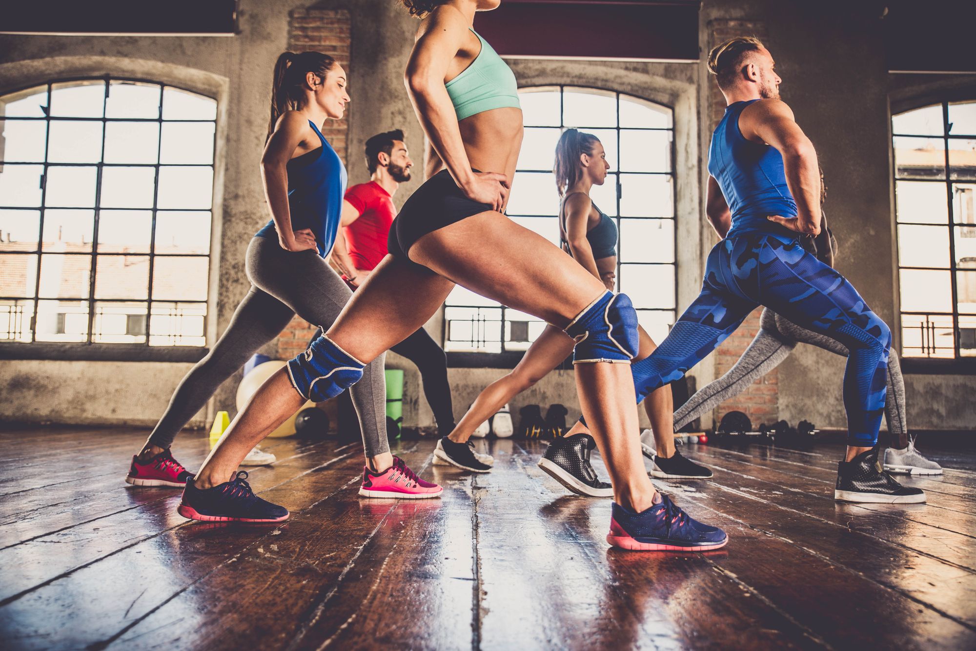 Multi-ethnic group of people training in a gym - Personal trainer and sportive persons in a fitness class