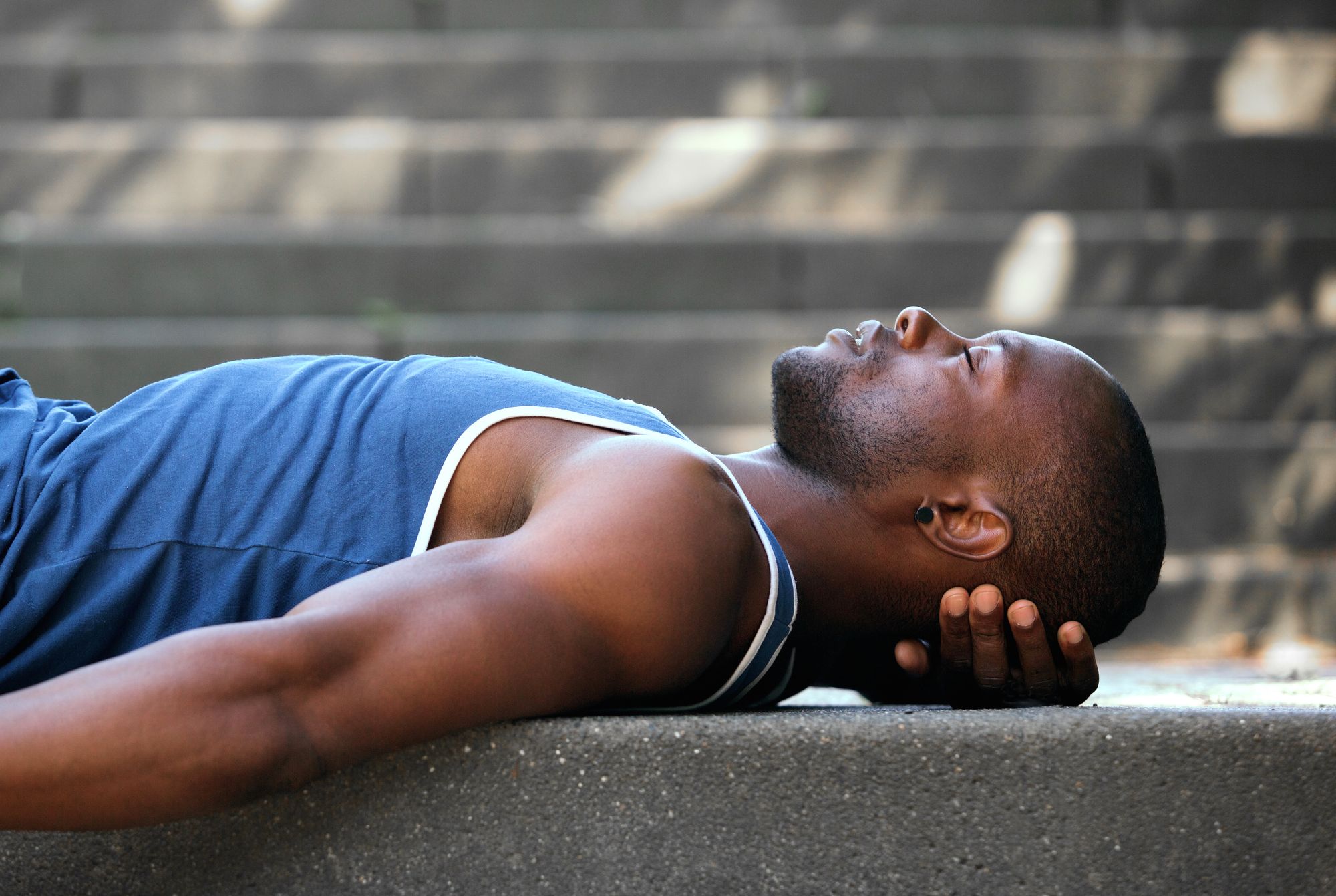 Side portrait of an African American man sleeping outside
