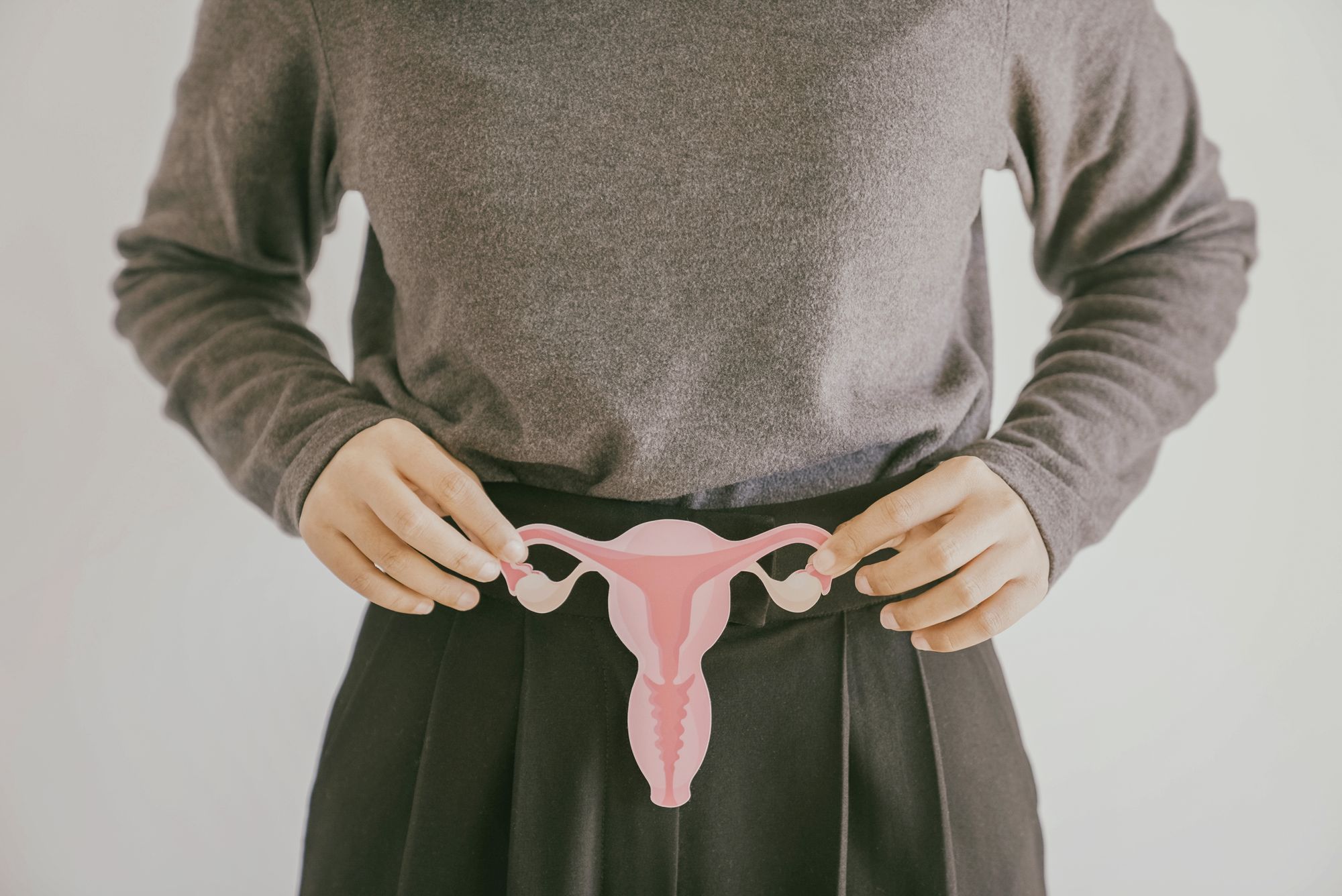 Woman hands holding uterus, female reproductive system ,PCOS, gynecologic and cervix cancer concept