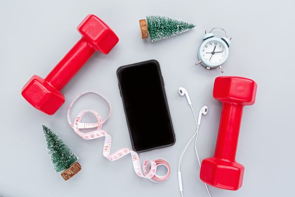 Gym accessories, mobile phone with clear screen, copy space, mockup. Sport goals in New Year