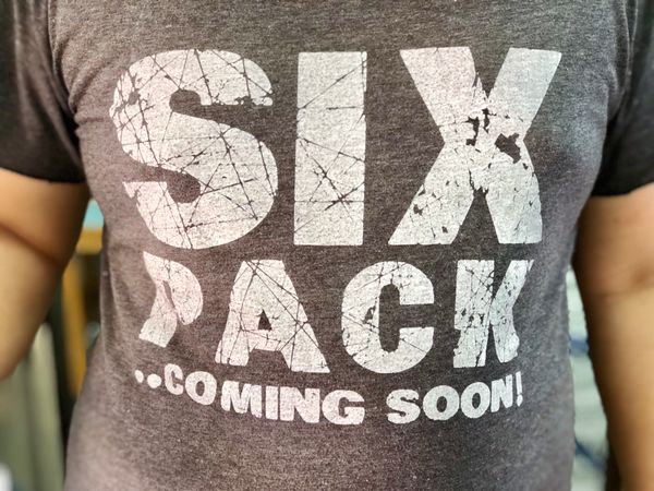 Man wearing T- shirt screen six pack inspires that he will start coming soon